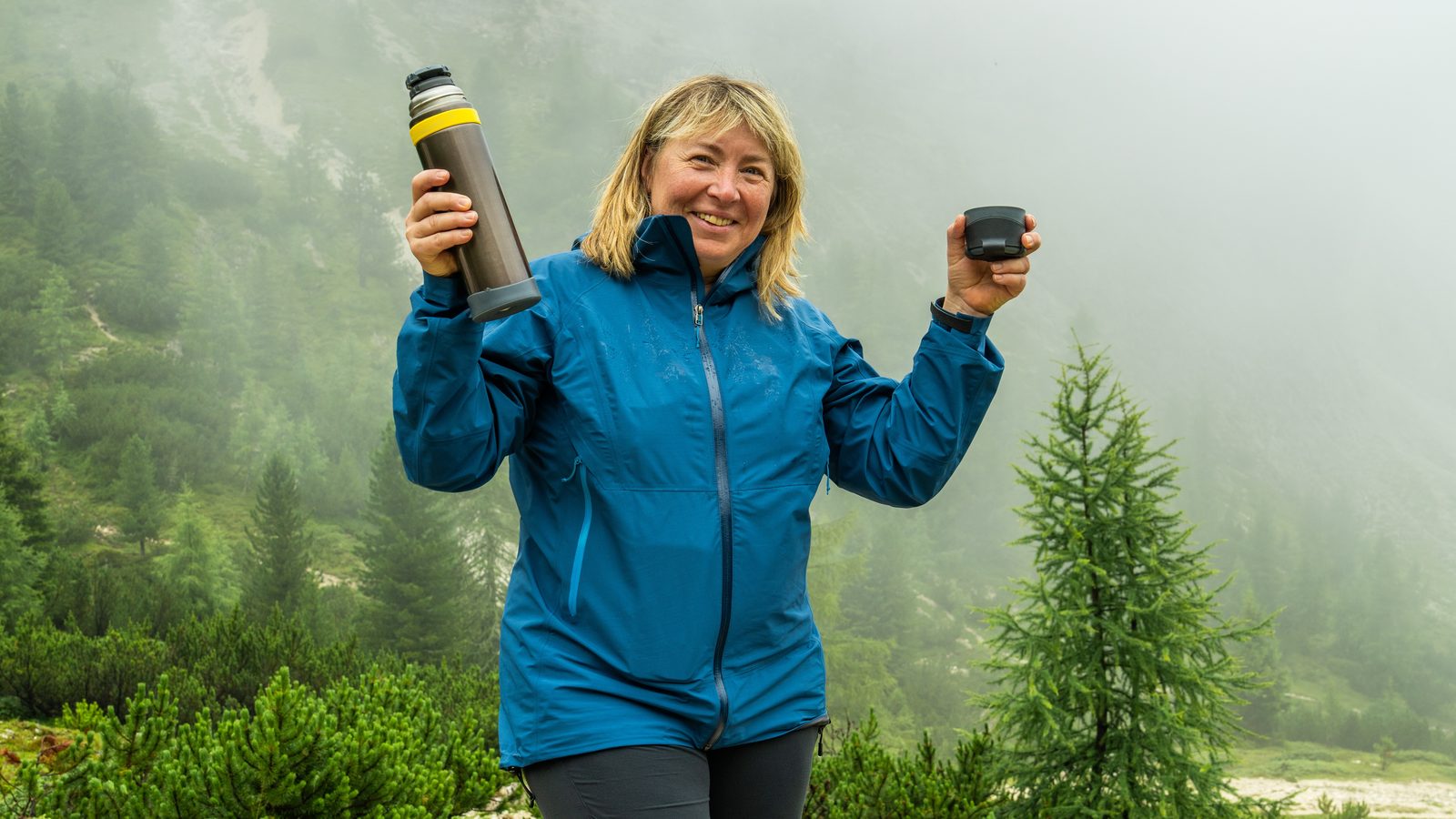 Wanderin mit Teekanne im nebligen Pinienwald